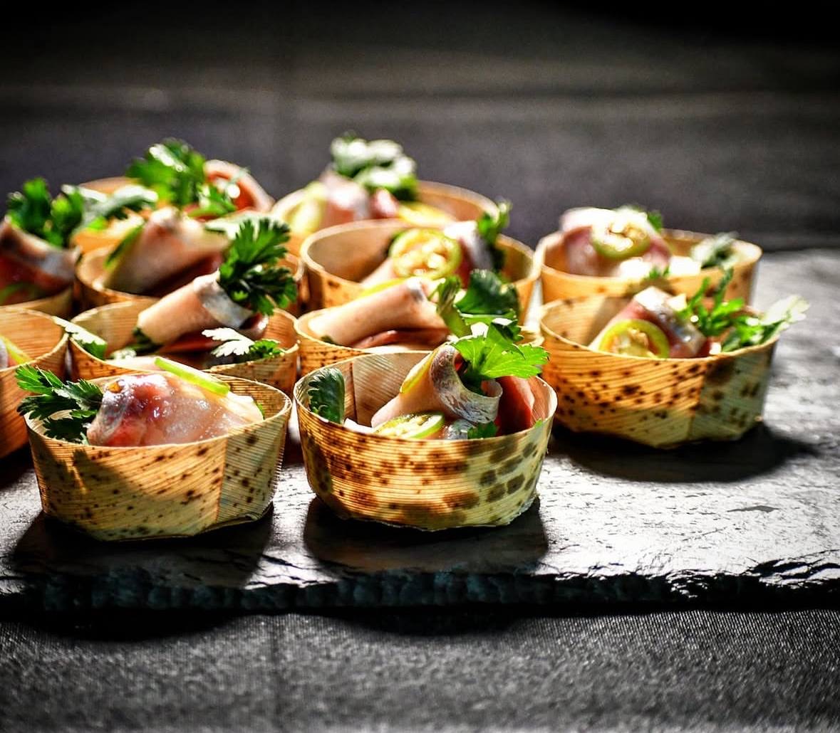 Sashimi in bamboo cups on slate